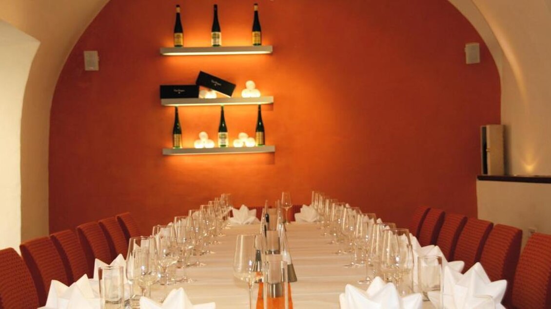 Ein eleganter Raum mit einem langen Tisch, der für eine Feier vorbereitet ist. Die Wände sind in warmen Farben gestrichen und elegant dekoriert. | © Stadtmeierei