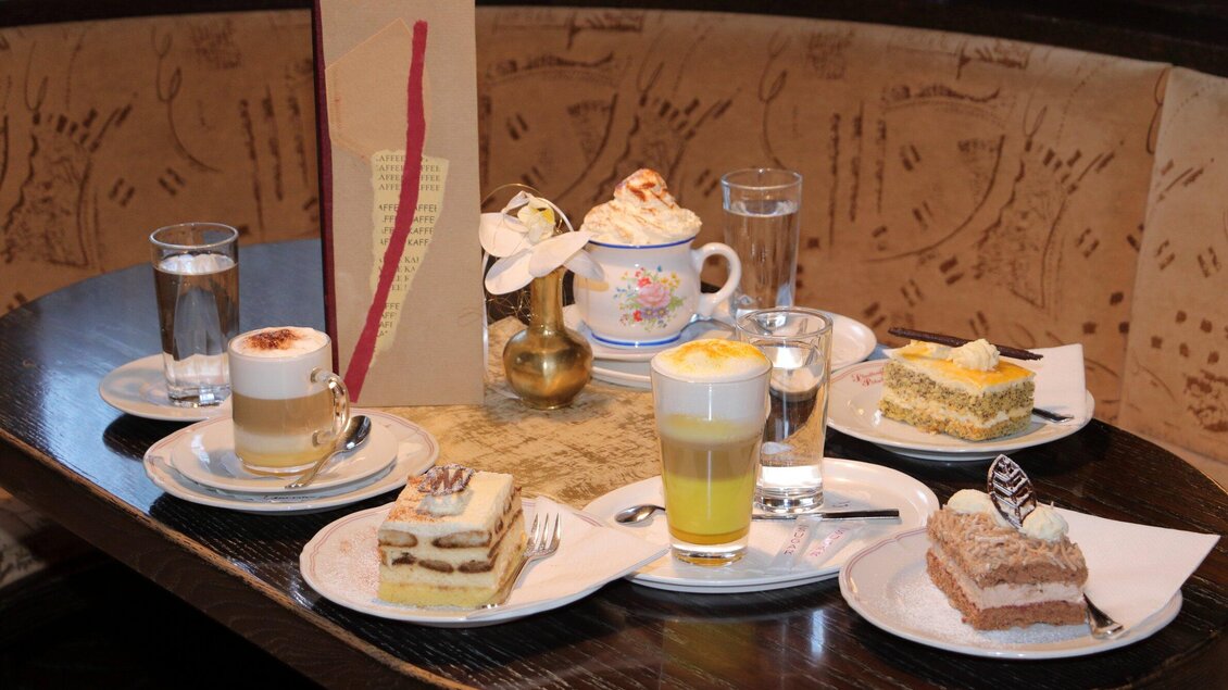 Eine Auswahl köstlicher Desserts und Getränke auf einem Tisch. Dazu gehören Torten, Kaffee und ein erfrischendes Getränk. | © Stadtcafe Pötscher