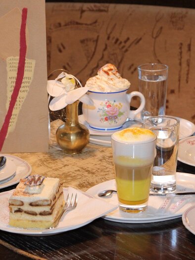 Eine Auswahl köstlicher Desserts und Getränke auf einem Tisch. Dazu gehören Torten, Kaffee und ein erfrischendes Getränk. | © Stadtcafe Pötscher