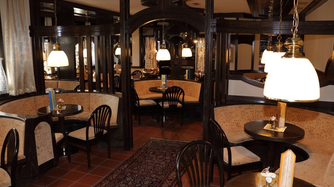 Ein gemütliches Café mit Holzinterieur und weichen Sitzbänken. Sanftes Licht von hängenden Lampen schafft eine einladende Atmosphäre. | © Stadtcafe Pötscher