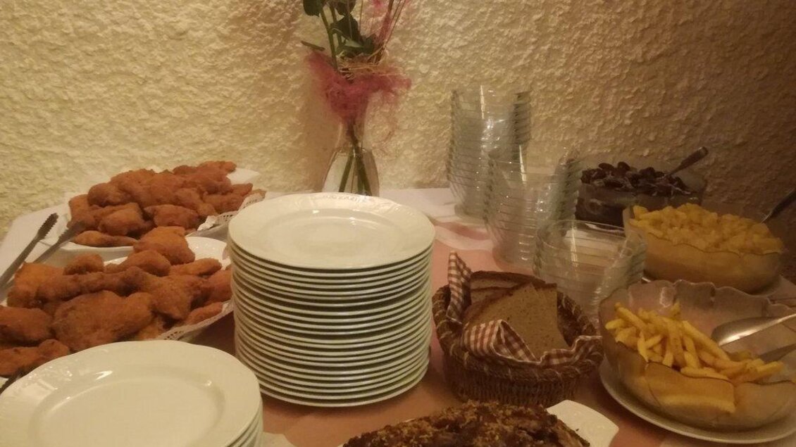 Ein gedeckter Tisch mit verschiedenen Gerichten, darunter Fleisch und Snacks. Im Hintergrund stehen Teller, Gläser und eine Blumendekoration. | © Stadtheuriger Trofaiach