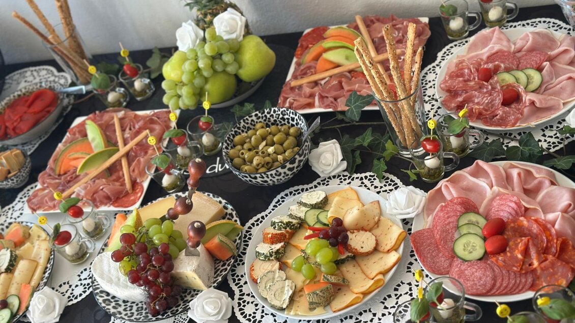 Ein schön angerichteter Tisch mit verschiedenen Häppchen, Wurst- und Käsesorten sowie frischem Obst. Die Platten sind liebevoll dekoriert und laden zum Genießen ein. | © TV Südsteiermark - Elvira Kos-Czerniecki
