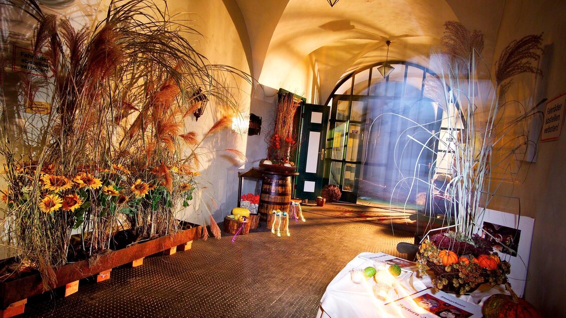 Ein einladender Flur mit Sonnenblumen und getrockneten Pflanzen. Das Licht schafft eine warme Atmosphäre. | © Stainzerbauer - Werner Krug