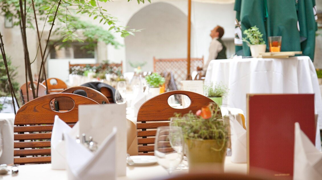 Ein gemütliches Restaurant mit Holztischen und Stühlen. Überall sind Pflanzen und eine elegante Tischdekoration zu sehen. | © Stainzerbauer