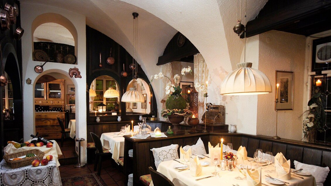 Ein gemütliches Restaurant mit warmem Licht und einladender Dekoration. Tische sind festlich gedeckt und es gibt eine angenehme Atmosphäre. | © Stainzerbauer