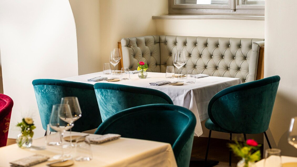 Ein elegantes Restaurant mit einem schön gedeckten Tisch und stilvollen Stühlen in Türkis. Die Atmosphäre ist gemütlich und einladend. | © Stammtisch - Paul Stajan
