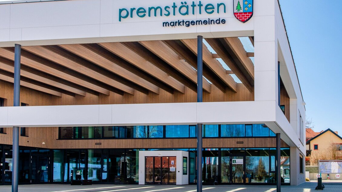 Ein modernes Gebäude mit Holzverkleidung und großen Fenstern. Darauf steht der Name „Premstätten Marktgemeinde“. | © Mias Photoart - Region Graz