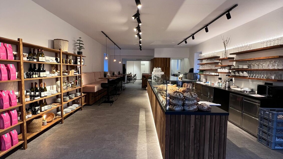 Ein moderner Laden mit Holzregalen und einem stilvollen Thekenbereich. Die Wände sind hell erleuchtet und der Boden ist aus grauem Stein. | © Bäckerei Steffl-Bäck