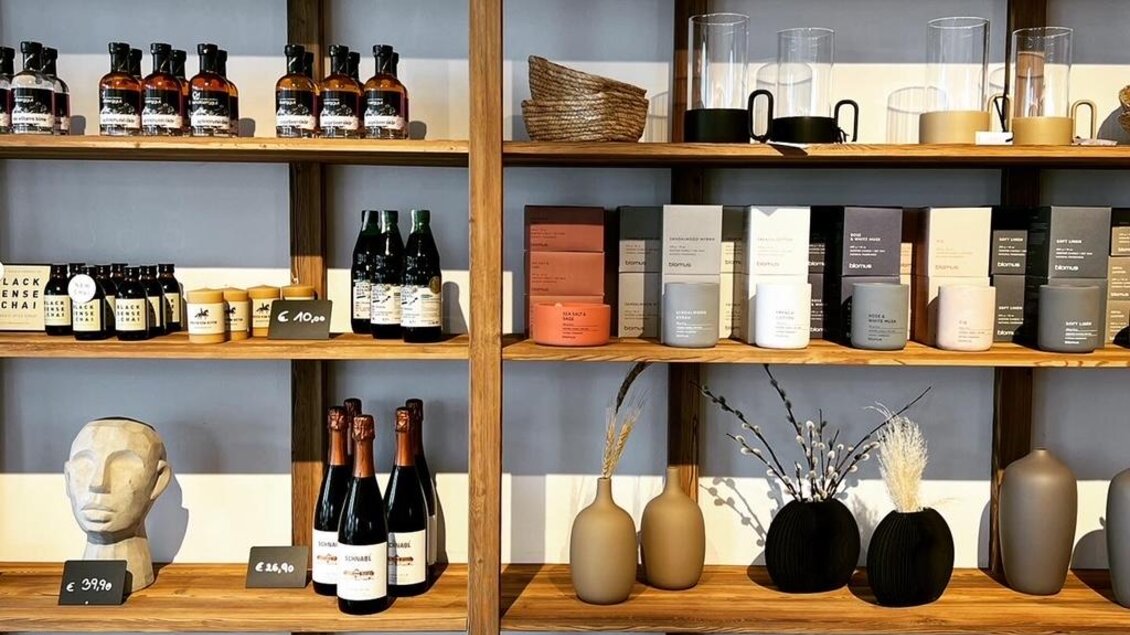 Ein Regalsystem voller stilvoller Dekorationsartikel und Lebensmittel. Die Produkte umfassen Keramik, Gläser und verschiedene Flaschen in warmen Farben. | © Steffl-Bäck Sebastian Knapp e.U.