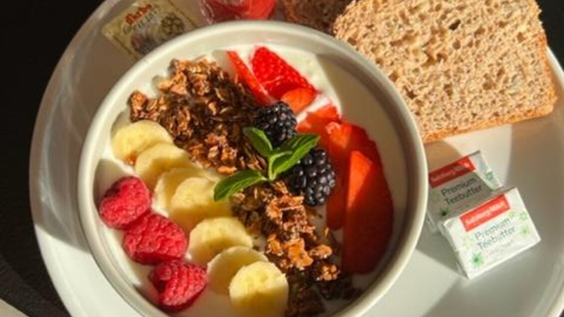 Ein gesundes Frühstück mit Joghurt, frischen Früchten wie Erdbeeren, Bananen und Himbeeren, sowie Müsli. Dazu gibt es Vollkornbrot und Marmelade. | © Steffl-Bäck Sebastian Knapp e.U.