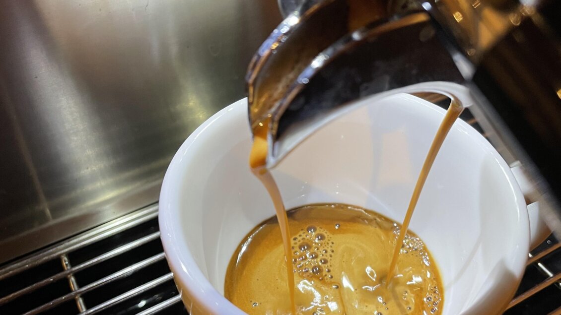 Eine Espresso-Maschine, die frisch gebrühten Kaffee in eine weiße Tasse leitet. Der Kaffee fließt gleichmäßig und bildet eine schöne Crema. | © Steffl-Bäck Sebastian Knapp