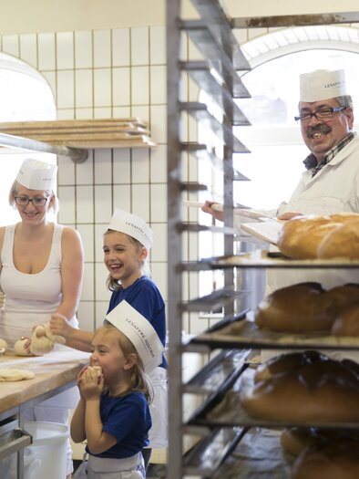 Eine Bäckerei mit bakenden Personen und frischem Brot. Die Atmosphäre ist freundlich und einladend. | © Thermen- und Vulkanland