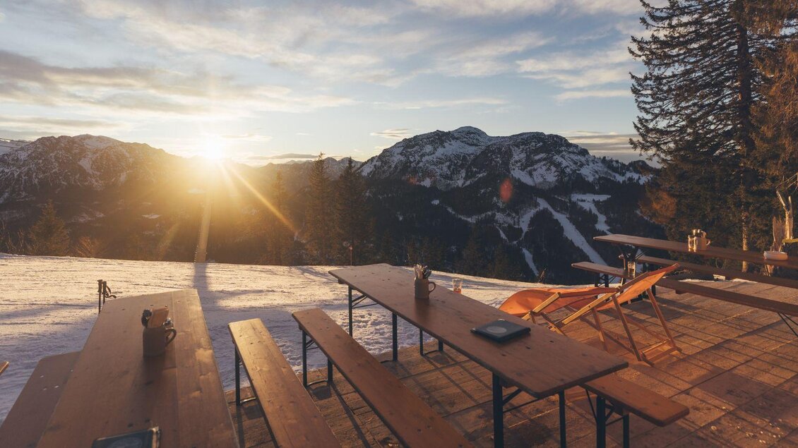 Eine gemütliche Terrasse in den Bergen mit beeindruckendem Sonnenuntergang. Tische und Liegestühle laden zum Entspannen ein. | © Krewenka