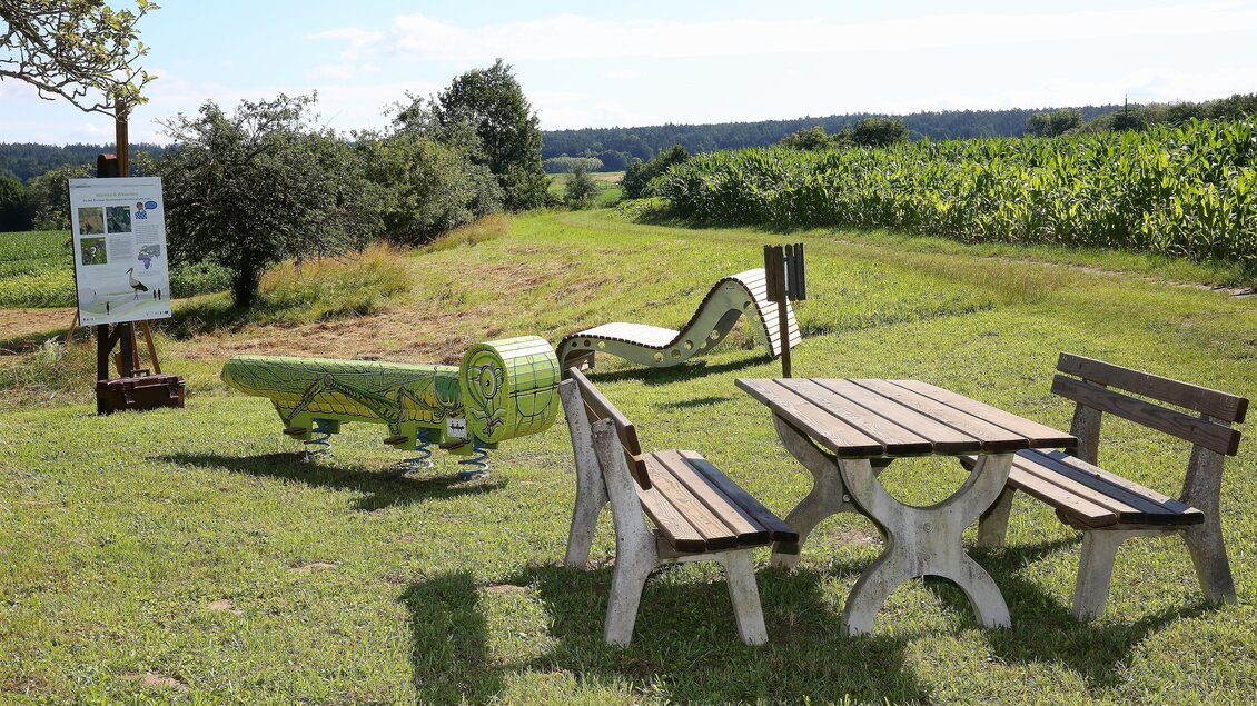 Ein schöner Platz im Freien mit Sitzgelegenheiten und einer Liegefläche. Im Hintergrund sind grüne Felder und ein blauer Himmel zu sehen. | © Kurkommission Bad Blumau