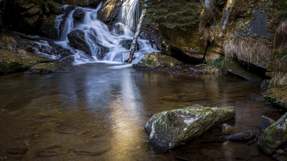 Ein schöner Wasserfall fließt in einen ruhigen Teich. Umgeben von grünen Bäumen und Felsen. | © Sulmwasserfall