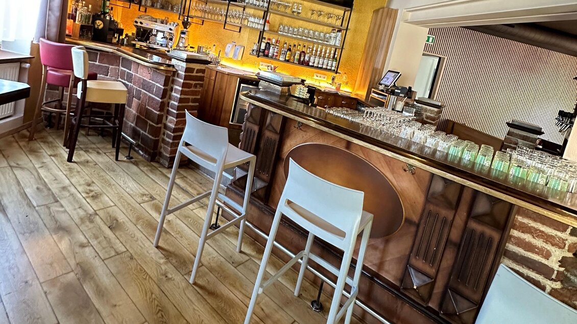 Eine gemütliche Bar mit Holzfußboden und einer breiten Auswahl an Getränken. Die Stühle sind modern, und das Licht schafft eine angenehme Atmosphäre. | © TREND