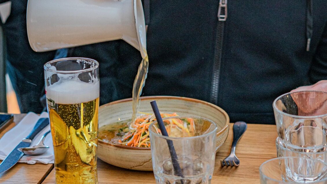 Am Tisch im Tagescafé Freiblick Graz wird Suppe eingeschenkt, dazu Bier und erfrischende Drinks | © Freiblick - Milena Bonstingl