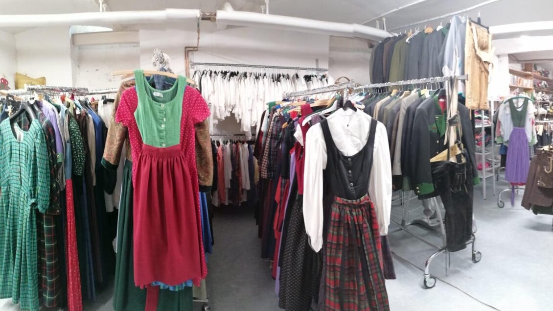 Ein Geschäft mit traditionellen Kleidern, die an Kleiderständern hängen. Die Kleidung ist bunt und zeigt verschiedene Stile und Muster. | © Erika Baumann