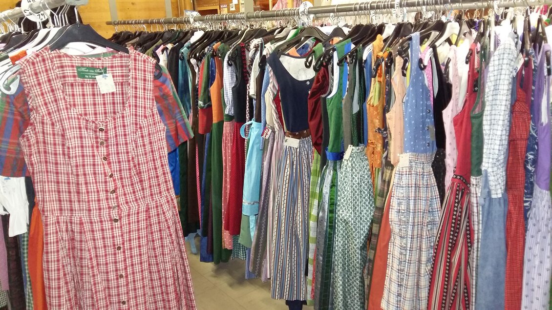 Ein Kleiderständer mit einer Vielzahl von bunten Kleidern. Im Vordergrund ist ein kariertes Kleid zu sehen, während weitere Modelle im Hintergrund hängen. | © Kirchschllager Petra