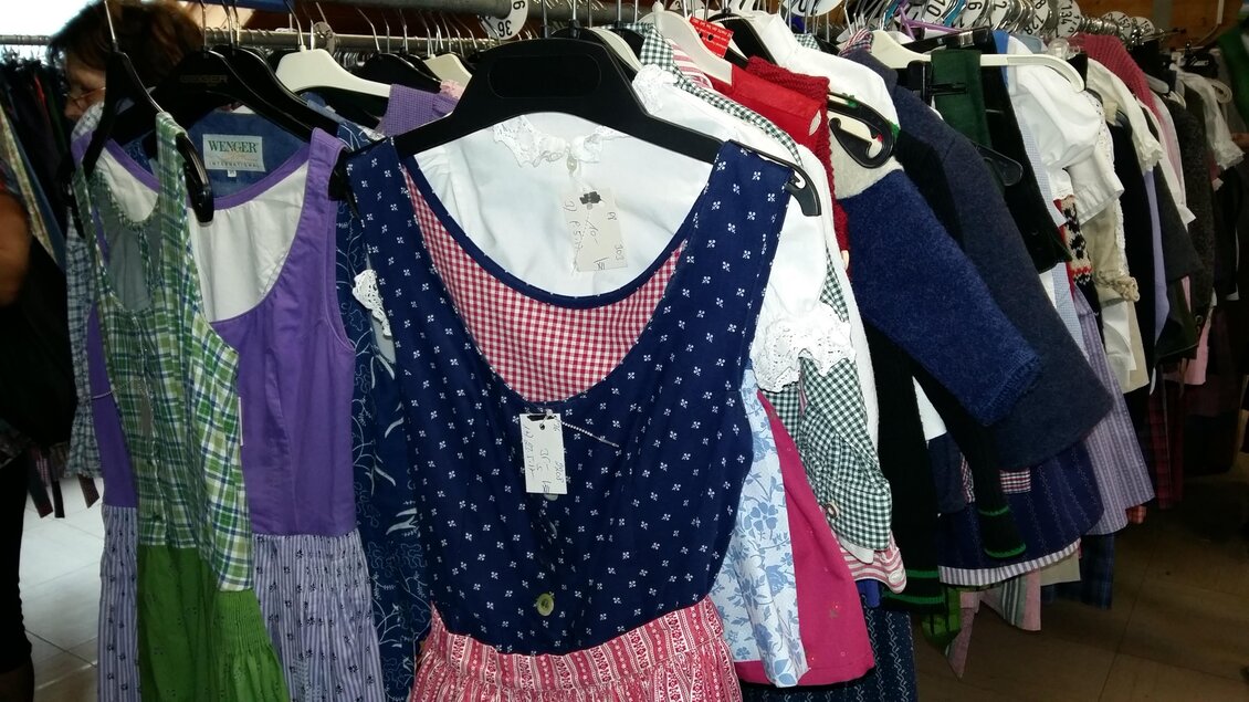 Ein bunter Kleiderständer mit verschiedenen Dirndln in unterschiedlichen Farben und Mustern. Die Kleider hängen ordentlich auf Bügeln und sind bereit zum Verkauf. | © Kirchschlager Petra