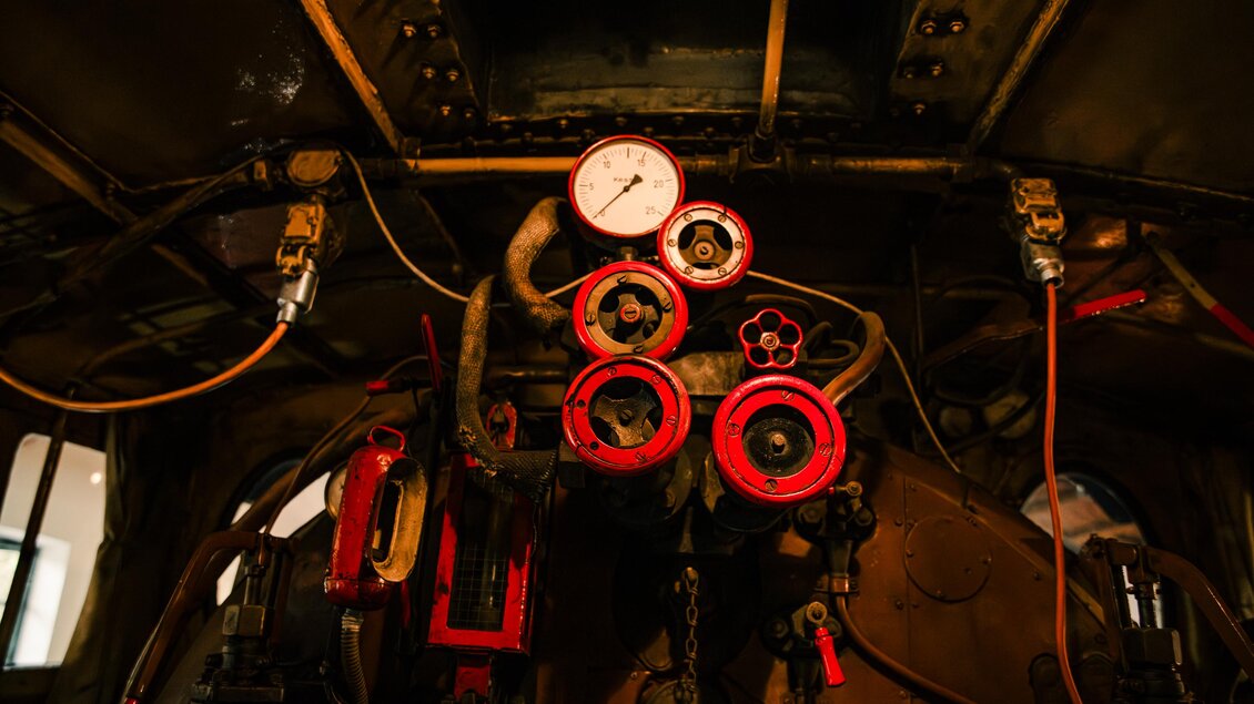 Ein Kontrollpanel mit vielen Druckmessgeräten und Rohren in einer Lokomotive für eine sichere Fahrt. Die roten Akzente heben die Wichtigkeit hervor, zu sehen im technischen Eisenbahnmuseum Lieboch.  | © Mias Photoart