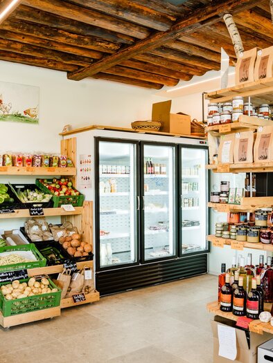 Ein einladender Lebensmittelladen mit frischem Gemüse und Obst. Regale sind mit verschiedenen Produkten, darunter Getränke und Konserven, gefüllt. | © Region Graz - Mias Photoart