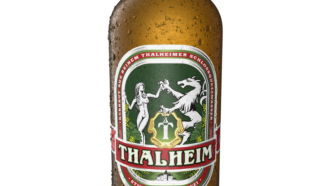 Eine Flasche Thalheim Pils mit einer erfrischenden, kühlen Oberfläche. Das Etikett zeigt traditionelle Motive und beinhaltet den Namen der Brauerei. | © Thalheimer Heilwasser GmbH Brauerei