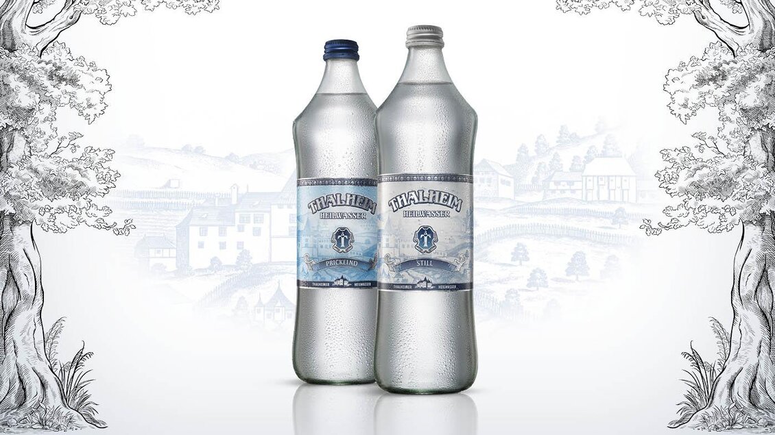 Zwei Flaschen Mineralwasser stehen in der Mitte vor einem skizzenhaften Hintergrund. Der Wassername und das Design vermitteln Frische und Natürlichkeit. | © Thalheimer Heilwasser GmbH Brauerei