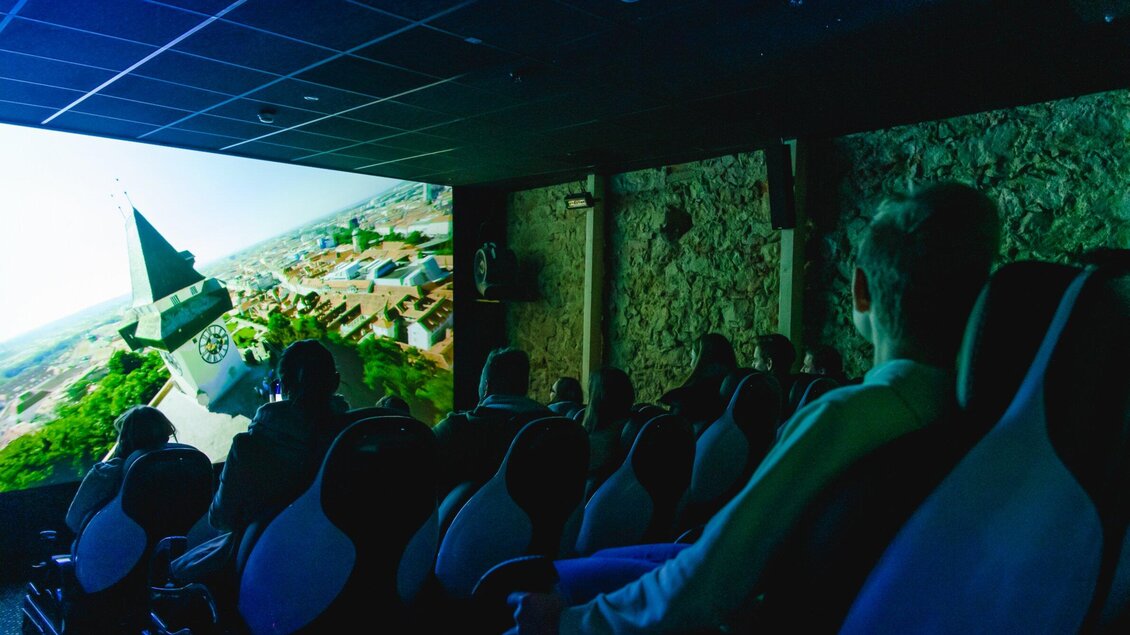 Ein moderner Kinosaal mit bequemen Sitzen. Die Zuschauer schauen einen beeindruckenden Film auf einer großen Bildschirmleinwand. | © Region Graz - Mias Photoart