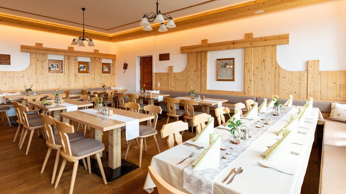 Ein helles, modernes Restaurant mit Holzinterieur und viel Sitzgelegenheit. Die Tische sind elegant gedeckt mit Blumen und Geschirr. | © TV Region Graz - Harry Schiffer