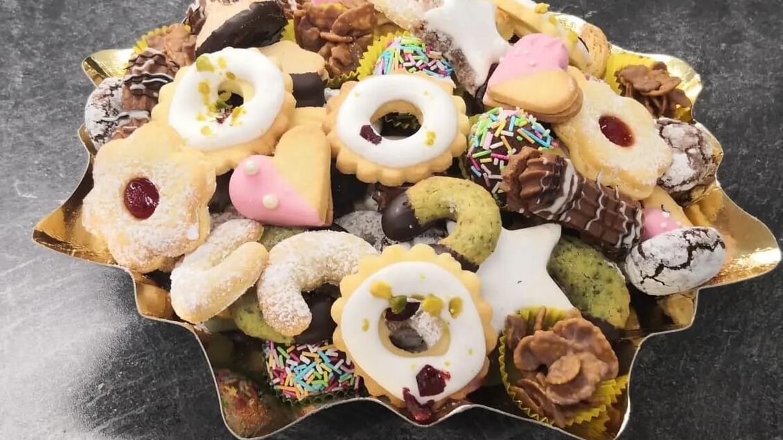 Ein Teller voller bunter Plätzchen und Kekse. Die Süßigkeiten haben verschiedene Formen und Farben und sind mit Zuckerguss und Streuseln dekoriert. | © Martina Pöltl / Nilepixx by Nicky Hoferfotografie