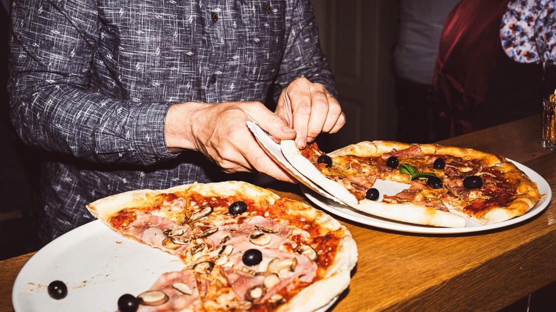 Zwei frisch gebackene Pizzen mit Schinken, Pilzen und Oliven im Restaurant Tintenfass in Graz | © Chiara Maria B.