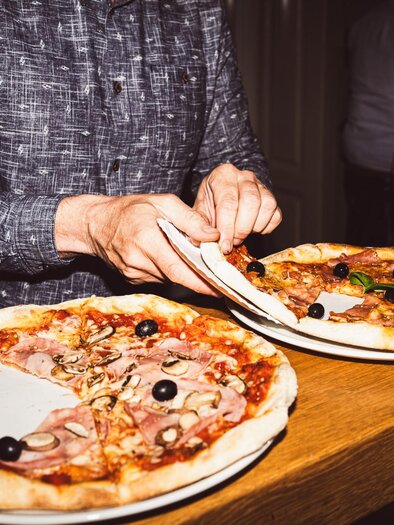 Zwei frisch gebackene Pizzen mit Schinken, Pilzen und Oliven im Restaurant Tintenfass in Graz | © Chiara Maria B.