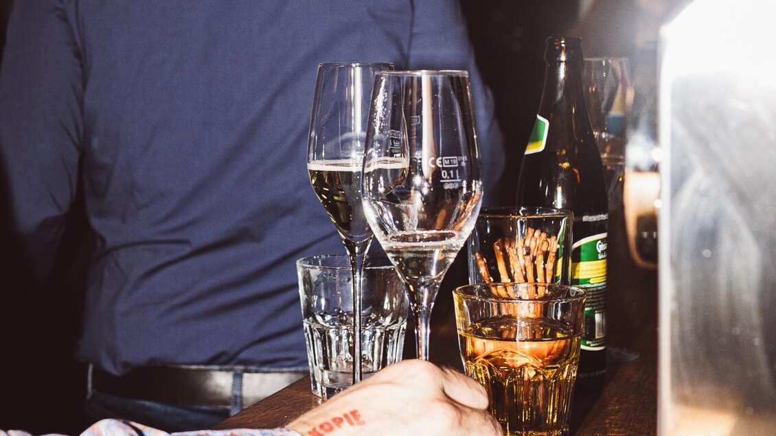 Gläser mit Wein, Bier und Snacks auf einer Theke bei Abendstimmung im Tintenfass Graz | © Chiara Maria B.