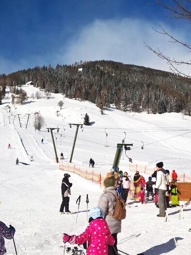A Baden ski resort with many people in the snow. Children and adults are skiing and enjoying the wintry landscape. | © Tourismusverband Murau