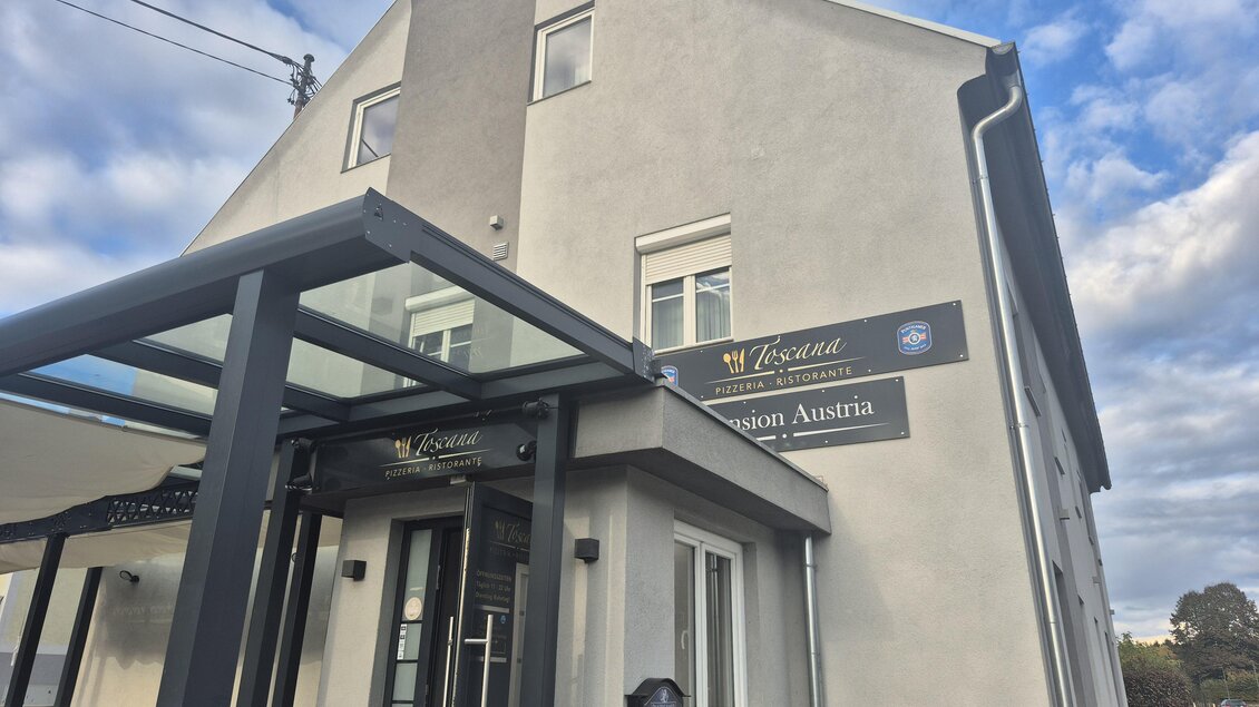 Ein modernes Gebäude mit einem Eingangsbereich und einer überdachten Terrasse. Der Himmel ist teilweise bewölkt. | © TV Hochsteiermark