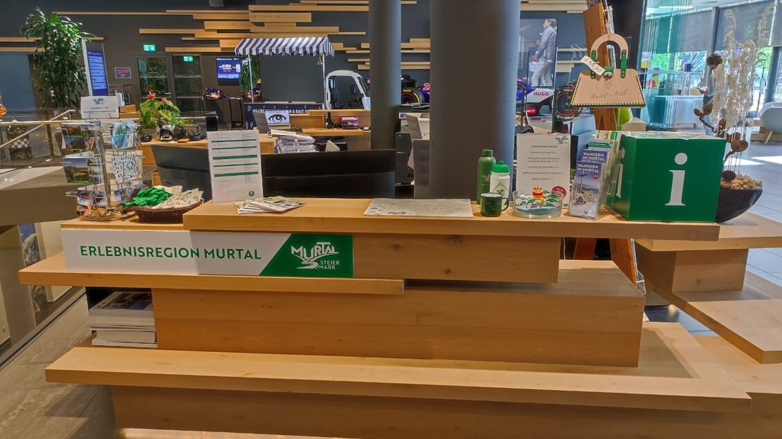 Ein Empfangstresen mit Informationen über die Erlebnisregion Murtal. Der Bereich ist modern gestaltet und bietet verschiedene Informationsmaterialien und Pflanzen. | © Patrizia Schreibmayr