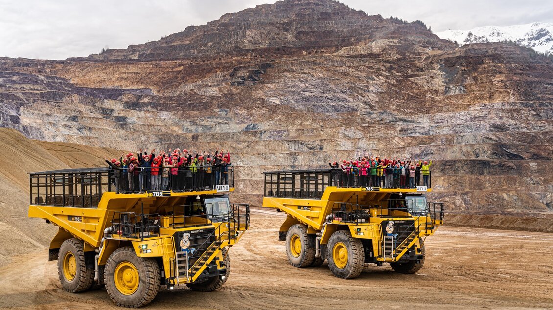 Zwei große Geländewagen stehen in einer Bergbaulandschaft. Eine Gruppe von Menschen steht auf den Ladeflächen und genießt die Aussicht. | © Harald Tauderer