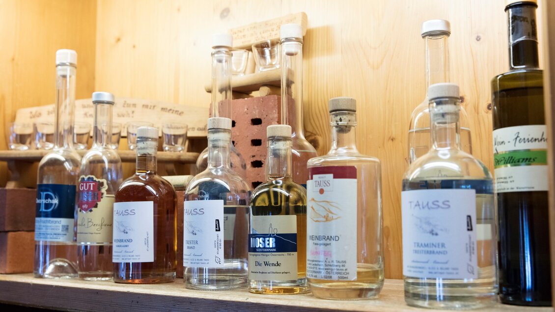 Eine Reihe von Flaschen mit verschiedenen Spirituosen auf einem Regal. Die Flaschen haben unterschiedliche Etiketten und Farben. | © Tscheppe
