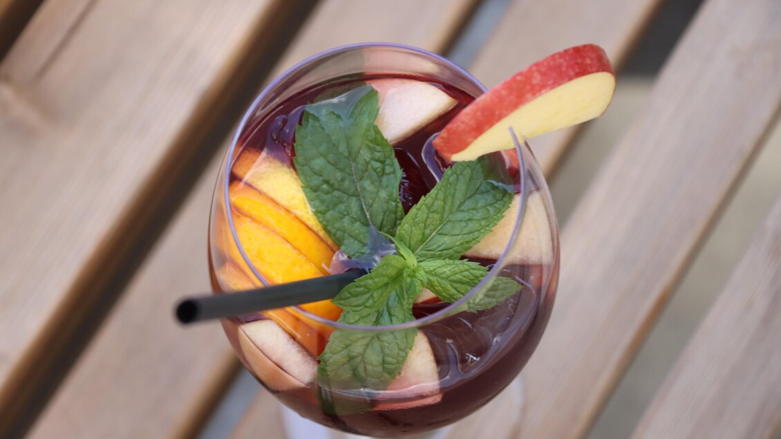 Ein Cocktail mit frischen Früchten und Minze. Auf einem Holztisch präsentiert, bietet er eine erfrischende Optik. | © © Urbanistub'n