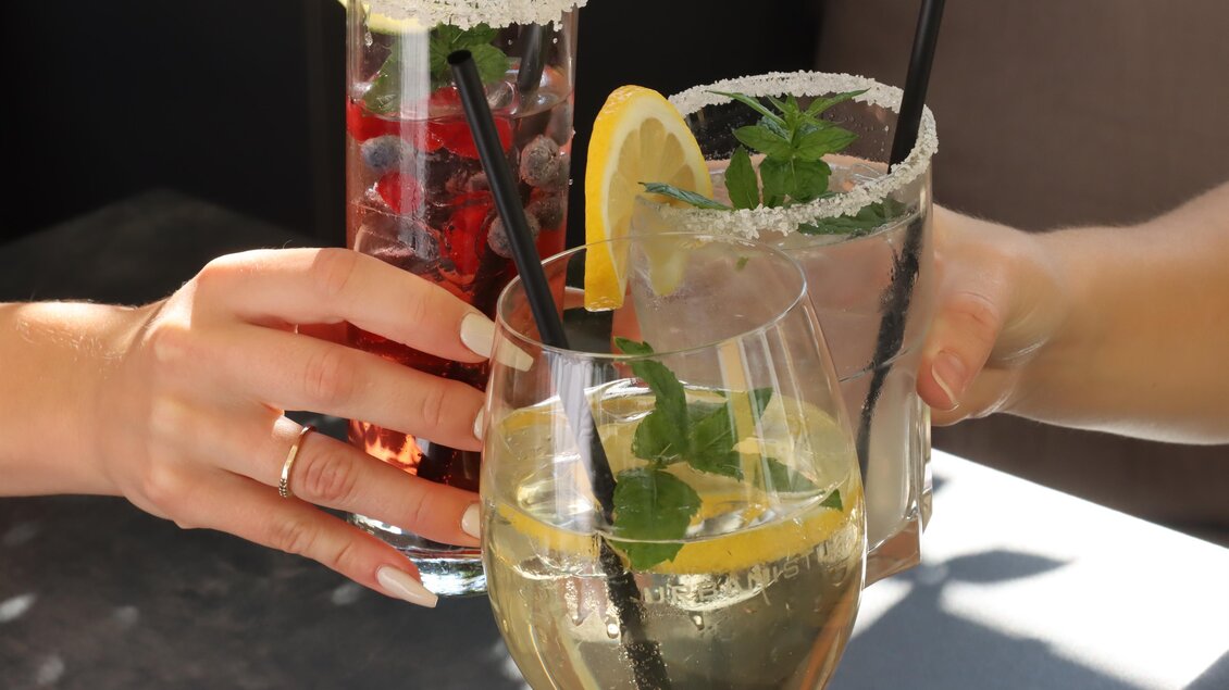 Drei Gläser mit erfrischenden Cocktails werden angestoßen. Die Drinks sind mit Früchten und Minze dekoriert. | © © Urbanistub'n