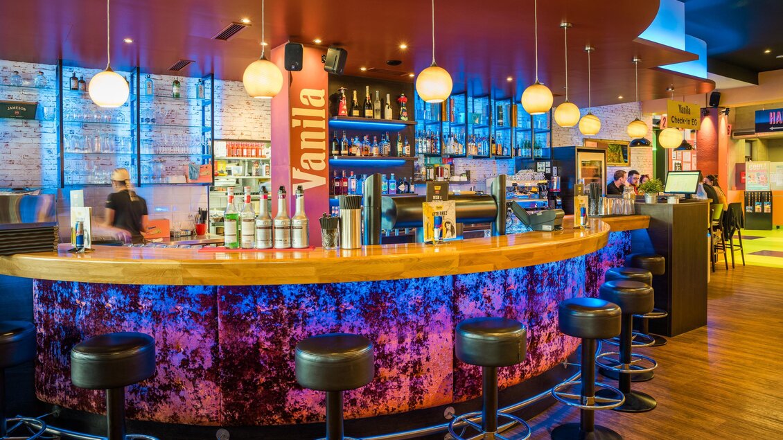 Eine moderne Bar mit einem attraktiven, beleuchteten Tresen. Die Einrichtung ist farbenfroh und einladend. | © Region Graz - Mias Photoart