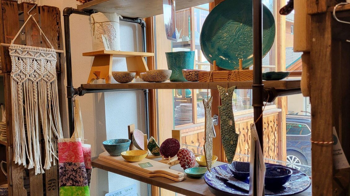 Ein Regal mit buntem Geschirr und dekorativen Gegenständen. Die Atmosphäre ist gemütlich und einladend. | © Petra Kirchschlager