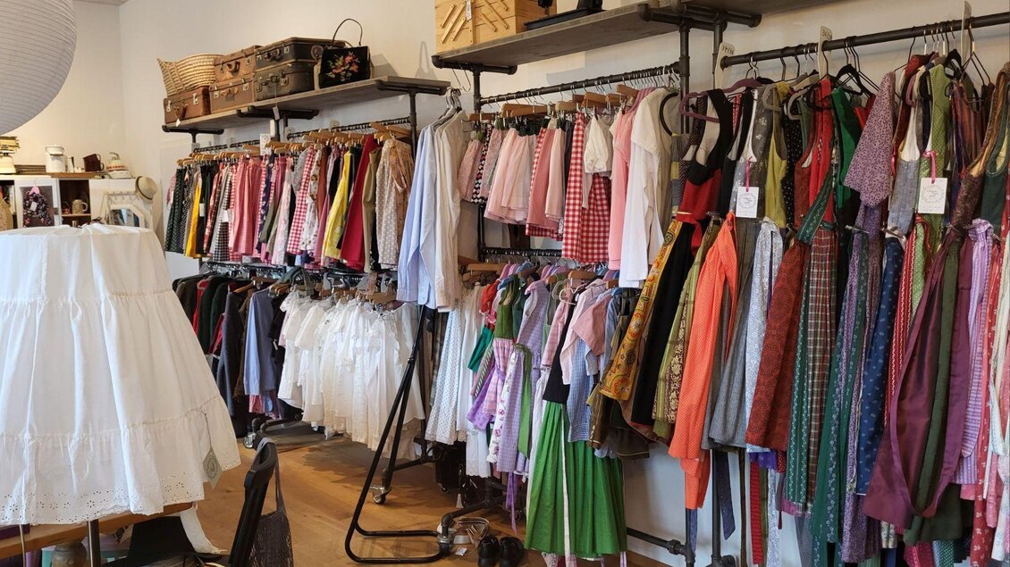 Ein Modegeschäft mit einer Vielzahl von bunten Kleidern und traditionellen Trachten an Kleiderstangen. Auffällig ist die helle, einladende Atmosphäre. | © Petra Kirchschlager