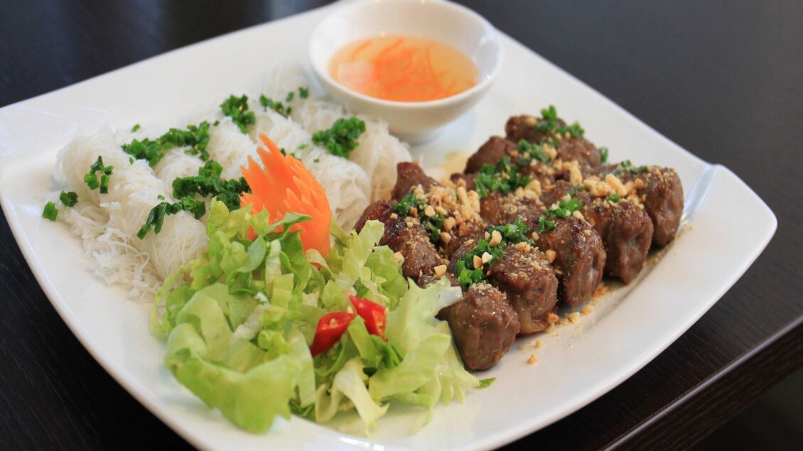 Ein Teller mit gegrilltem Fleisch, frischen Kräutern und Erdnüssen. Dazu gibt es Reisnudeln, Salat und eine dipping Sauce. | © Vina