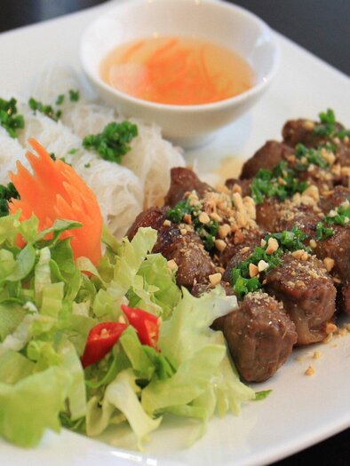Ein Teller mit gegrilltem Fleisch, frischen Kräutern und Erdnüssen. Dazu gibt es Reisnudeln, Salat und eine dipping Sauce. | © Vina