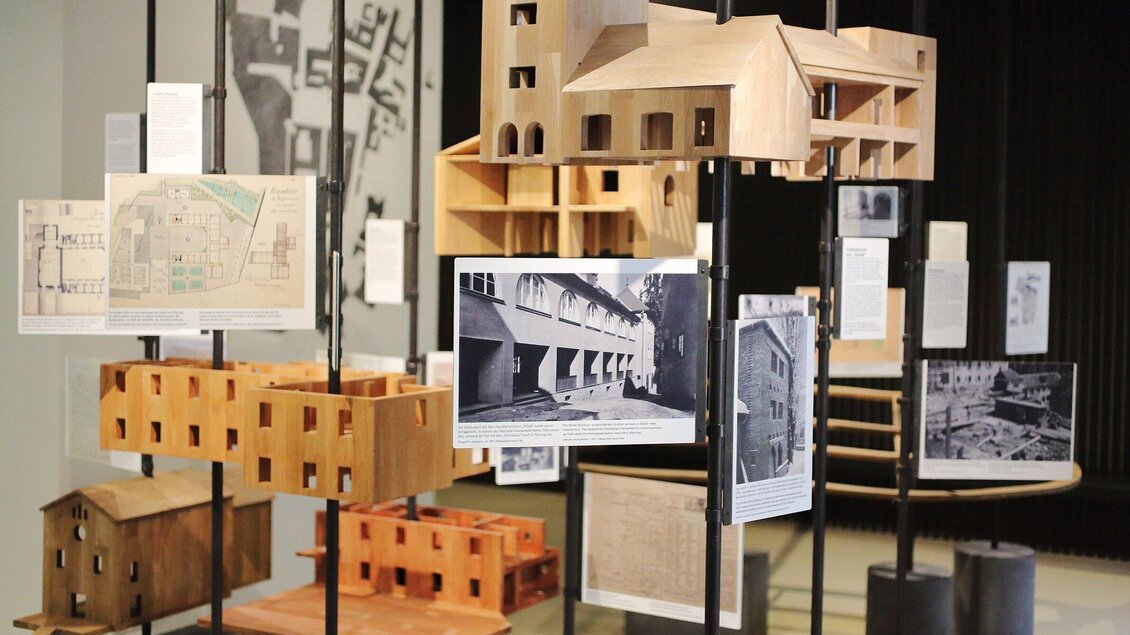 Ein Ausstellungsraum mit Architekturmodellen und Plänen. Die Objekte sind auf Ständern angeordnet und zeigen verschiedene Designs. | © Universalmuseum Joanneum - J. Kucek +
