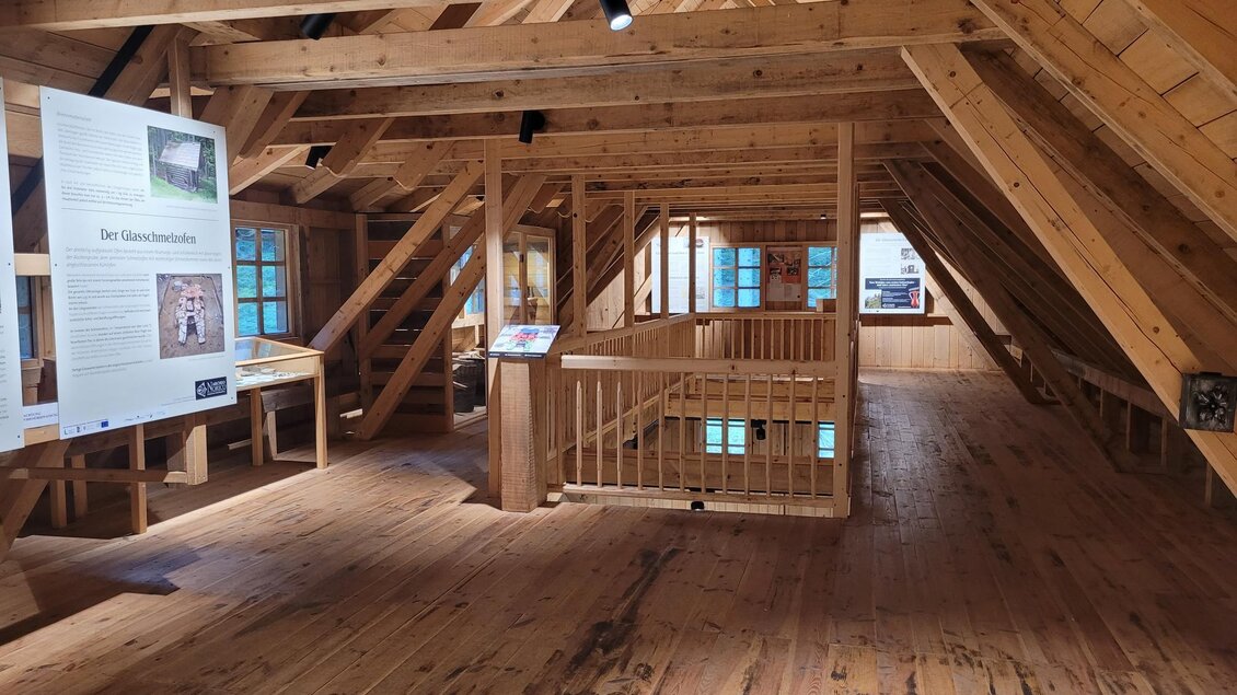 Ein helles Dachgeschoss mit Holzbalken und einem Holzfußboden. Es gibt Informationsschilder und große Fenster, die Tageslicht hereinlassen. | © TV Südsteiermark - Irene Löschnig