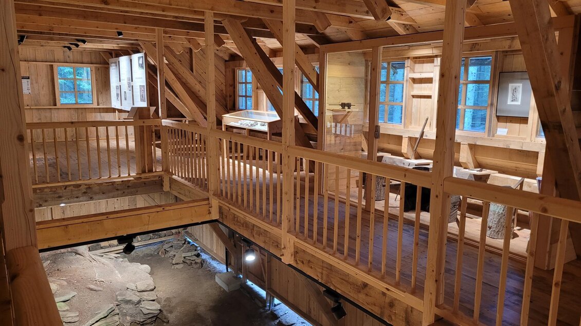 Ein Holzgebäude mit einer offenen Galerie und großen Fenstern. Der Innenraum ist freundlich und einladend, mit sichtbaren Holzbalken. | © TV Südsteiermark - Irene Löschnig