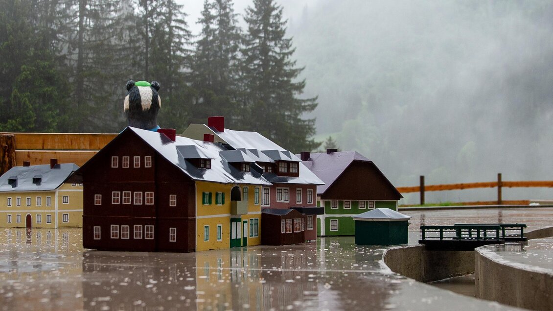 Ein Miniaturdorf bei regnerischem Wetter. Die Gebäude sind umgeben von Bäumen und Nebel. | © Martin Huber
